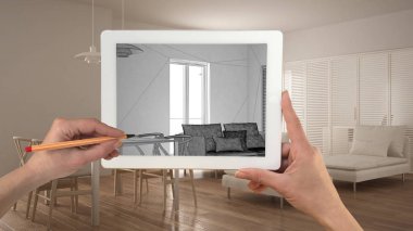 Holding ve tablet gösteren modern oturma odası mutfak çizim el kroki. Gerçek bitmiş minimalist beyaz ve ahşap proje mimari iç tasarım sunum arka planda