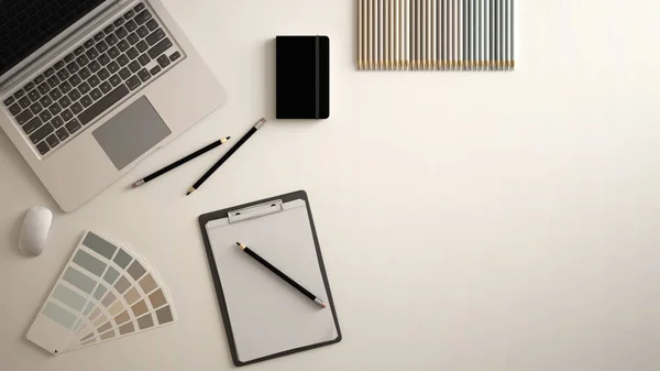 Stylish minimal office table desk. Workspace with laptop, notebook, pencils and sample color palette on white background. Flat lay, top view