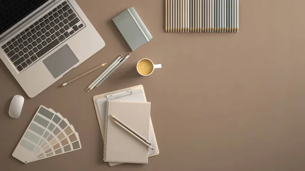 Stylish minimal office table desk. Workspace with laptop, notebook, pencils, coffee cup and sample color palette on pastel beige background. Flat lay, top view