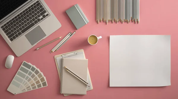 Stylish minimal office table desk. Workspace with laptop, notebook, pencils, coffee cup and sample color palette on pastel pink background. Flat lay, top view, blank paper mockup template
