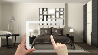 Artırılmış gerçeklik kavramı. Gerçek bir ev, otel yatak mobilya ve iç tasarım ürünleri benzetimini yapmak için kullanılan Ar uygulaması ile tablet tutan el