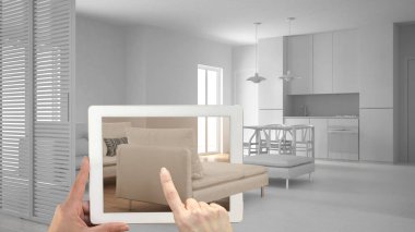 Artırılmış gerçeklik kavramı. Gerçek bir ev, modern oturma odası ile mutfak mobilya ve iç tasarım ürünler benzetimini yapmak için kullanılan Ar uygulaması ile tablet tutan el