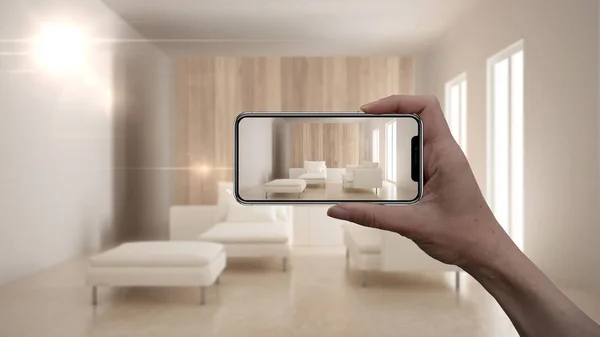 Hand holding smart phone, AR application, simulate furniture and interior design products in real home, architect designer concept, blur background, modern living room