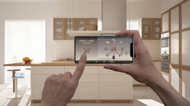 Uzaktan ev kontrol sistemi dijital akıllı telefon tablet. Aygıt app simgeleri ile. İç mimari tasarım arka planda beyaz minimalist mutfak
