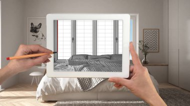 Holding ve tablet gösteren modern yatak odası üzerinde çizim eller Cad kroki. Gerçek bitmiş minimalist beyaz ve ahşap yatak odası arka planda, mimari iç tasarım sunum