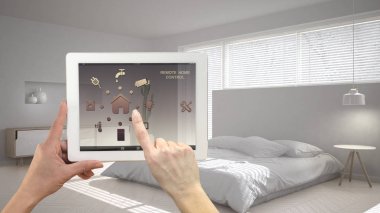Akıllı uzaktan ev kontrol sistemi dijital tablet. Aygıt app simgeleri ile. Mimari iç tasarım arka planda minimalist modern parlak yatak odası