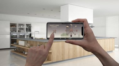 Uzaktan ev kontrol sistemi dijital akıllı telefon tablet. Aygıt app simgeleri ile. İç mimari tasarım arka planda profesyonel modern ahşap mutfak