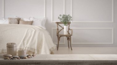 Ahşap antika masa üstü veya mumlar ve çakıl, zen ruh hali ile raf üzerinde bulanık vintage klasik yatak yumuşak yatak yastık ve battaniye, en az mimari iç tasarım dolu