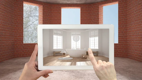 Augmented reality concept. Hand holding tablet with AR application used to simulate furniture and design products in an interior construction site, classic bathroom with bathtub