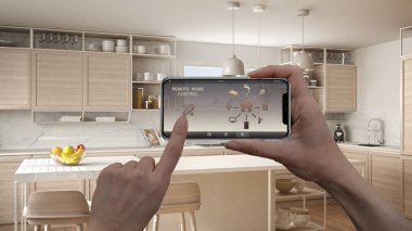 Uzaktan ev kontrol sistemi dijital akıllı telefon tablet. Aygıt app simgeleri ile. İç mimari tasarım arka planda minimalist beyaz ve ahşap mutfak