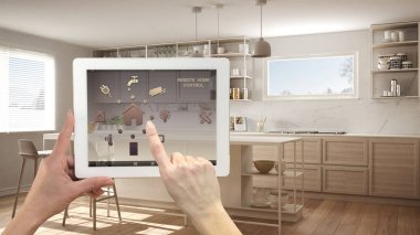 Akıllı uzaktan ev kontrol sistemi dijital tablet. Aygıt app simgeleri ile. Mimari iç tasarım arka planda minimalist modern parlak mutfak