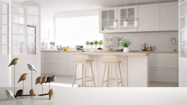 ホワイト テーブル トップやミニマルな鳥の飾り棚、小物 - 島やスツール、モダンなインテリア デザインとぼやけている現代的な白い北欧キッチン上のコツをバーディー — ストック写真