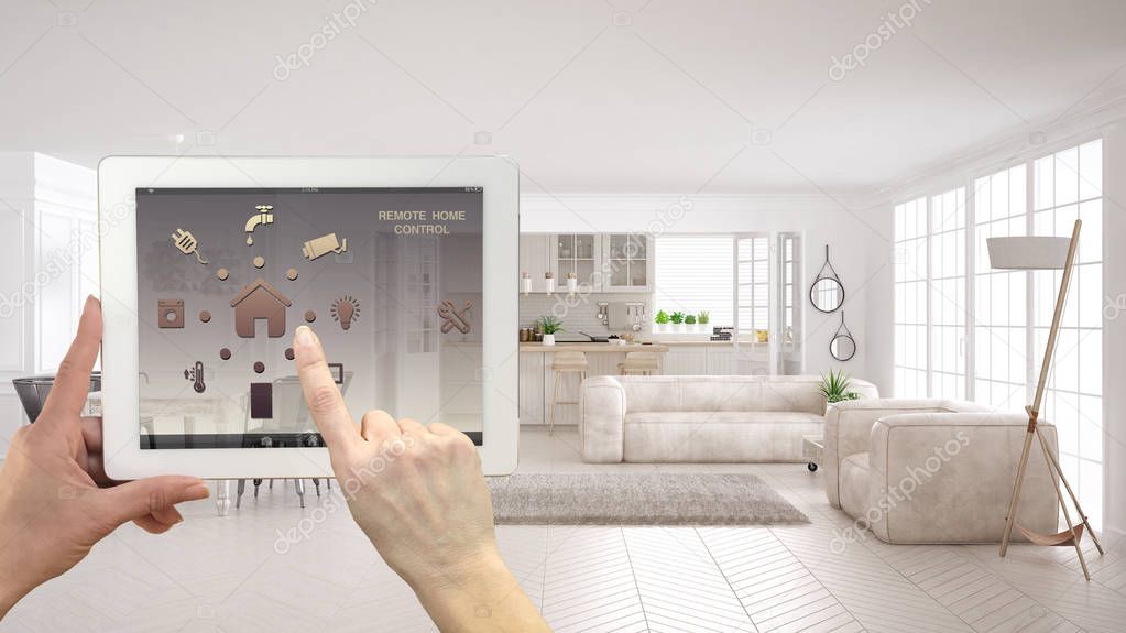 Smart remote home control system on a digital tablet. Device with app icons. Modern scandinavian living room with sofa and kitchen in the background, architecture interior design