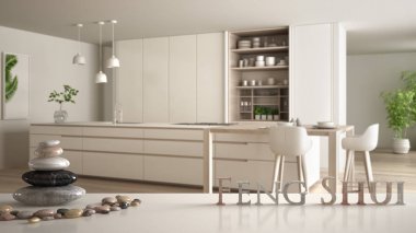 Beyaz masa veya raf çakıl dengesi ve 3d harfleri ahşap ve bej detayları ile bulanık modern mutfak üzerinde kelime feng shui yapma, zen kavramı iç tasarım