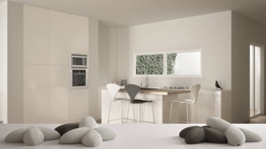 Beyaz masa, masa veya raf yıldız veya çiçek şeklinde beş yumuşak beyaz yastıklar ile, bulanık modern beyaz mutfak üzerinde, minimalist mimari iç tasarım konsepti