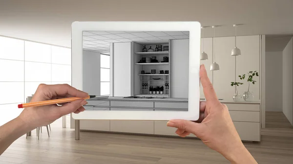 Hands holding and drawing on tablet showing modern white kitchen with wooden details CAD sketch. Real finished interior in the background, architecture design presentation — Stock Photo, Image