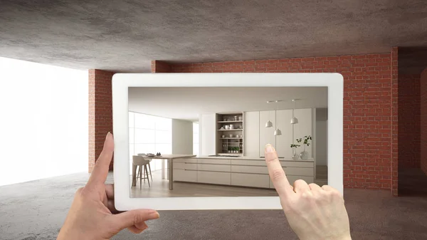 Concept de réalité augmentée. Tablette de maintien de la main avec application AR utilisée pour simuler les meubles et les produits de design sur le chantier de construction intérieure, cuisine moderne avec îlot et tabourets — Photo