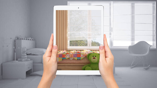 Hands holding tablet showing colored kids bedroom, total blank project background, augmented reality concept, application to simulate furniture and interior design products