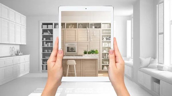 Mãos segurando tablet mostrando cozinha moderna branca e de madeira, fundo total do projeto em branco, conceito de realidade aumentada, aplicação para simular móveis e produtos de design de interiores — Fotografia de Stock