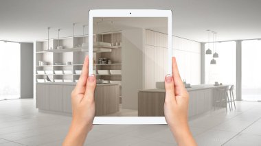 Modern beyaz ve ahşap mutfak gösteren eller tutma tablet, toplam boş proje arka plan, artırılmış gerçeklik konsepti, uygulama mobilya ve iç tasarım ürünleri simüle etmek