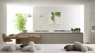 Beyaz masa, masa veya raf yıldız veya çiçek şeklinde beş yumuşak beyaz yastıklar ile, bulanık modern beyaz mutfak üzerinde, minimalist mimari iç tasarım konsepti