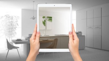 Modern beyaz ve ahşap mutfak gösteren eller tutma tablet, toplam boş proje arka plan, artırılmış gerçeklik konsepti, uygulama mobilya ve iç tasarım ürünleri simüle etmek