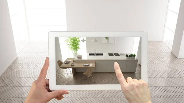 Augmented Reality concept. Hand vasthouden tablet met ar toepassing gebruikt voor het simuleren van meubels en design producten in lege interieur met parketvloer, moderne witte keuken, Top uitzicht — Stockfoto