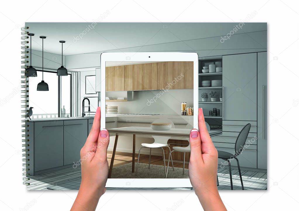 Hands holding tablet showing kitchen, notebook with blueprint sketch in the background, augmented reality concept, application to simulate furniture and interior design products