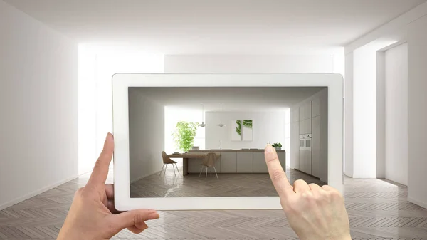 Conceito de realidade aumentada. Tablet de mão com aplicação AR usado para simular móveis e produtos de design em interior vazio com piso em parquet, cozinha branca moderna — Fotografia de Stock