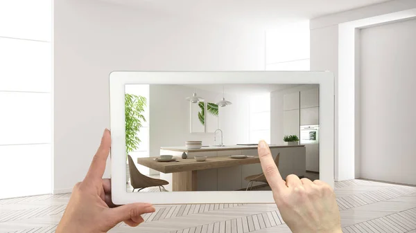 Augmented reality concept. Hand holding tablet met Ar toepassing gebruikt om te simuleren van meubelen en design producten in leeg interieur met parketvloer, moderne witte keuken — Stockfoto