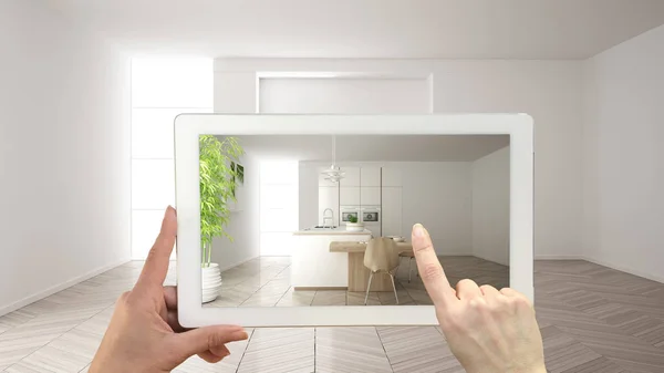 Conceito de realidade aumentada. Tablet de mão com aplicação AR usado para simular móveis e produtos de design em interior vazio com piso em parquet, cozinha branca moderna — Fotografia de Stock