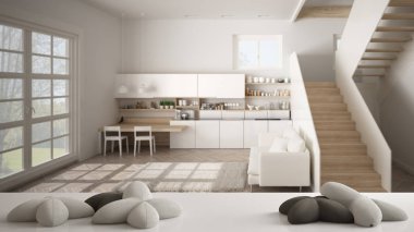 Beyaz masa, masa veya raf yıldız veya çiçek şeklinde beş yumuşak beyaz yastıklar, merdivenile bulanık modern beyaz mutfak üzerinde, minimalist mimari iç tasarım konsepti