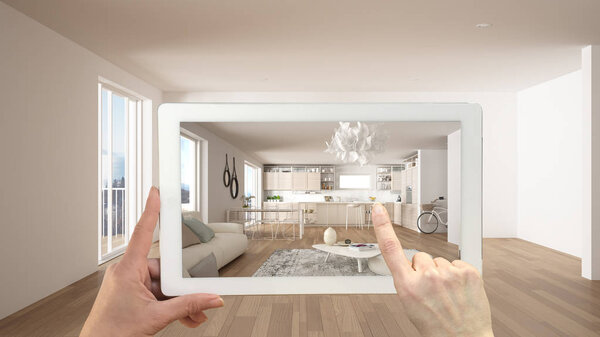 Augmented reality concept. Hand holding tablet with AR application used to simulate furniture and design products in empty interior with ceramic floor, modern white kitchen