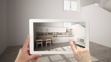 Artırılmış gerçeklik kavramı. Parke zeminli boş iç mekanda mobilya ve tasarım ürünlerini simüle etmek için kullanılan Ar uygulaması ile el tutma tableti, merdivenli beyaz mutfak