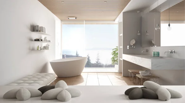 White table, desk or shelf with five soft white pillows in the shape of stars or flowers, over minimalist luxury bathroom with bathtub, minimalist architecture interior design concept
