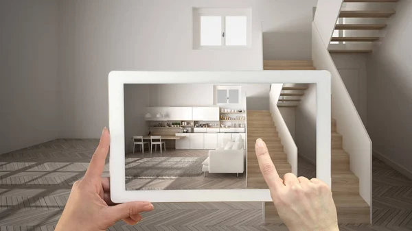 Koncepcja rozszerzonej rzeczywistości. Ręczny tablet z aplikacją AR używaną do symulacji mebli i produktów projektowych w pustych wnętrzach z parkietem, białą kuchnią z klatką schodową — Zdjęcie stockowe