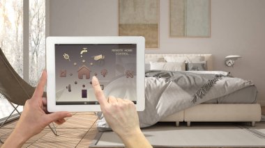 Akıllı uzaktan ev kontrol sistemi dijital tablet. Aygıt app simgeleri ile. Mimari iç tasarım arka planda minimalist modern parlak yatak odası