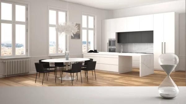 Biały stół lub półka z kryształową klepsydra mierzącą czas mijania ponad minimalistyczną białą kuchnią ze stołem, architekturą wnętrz, kopią tła — Zdjęcie stockowe