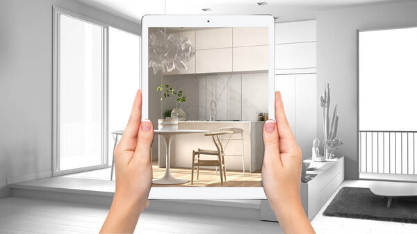 Hands holding tablet showing modernl kitchen, total blank project background, augmented reality concept, application to simulate furniture and interior design products