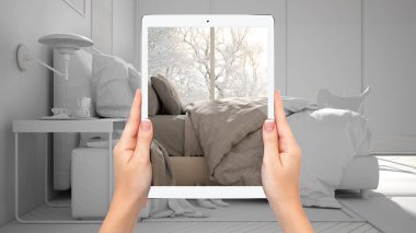 Büyük pencereli modern yatak odası nı gösteren el ele tablet, toplam boş proje arka planı, artırılmış gerçeklik konsepti, mobilya ve iç tasarım ürünlerini simüle etmek için uygulama