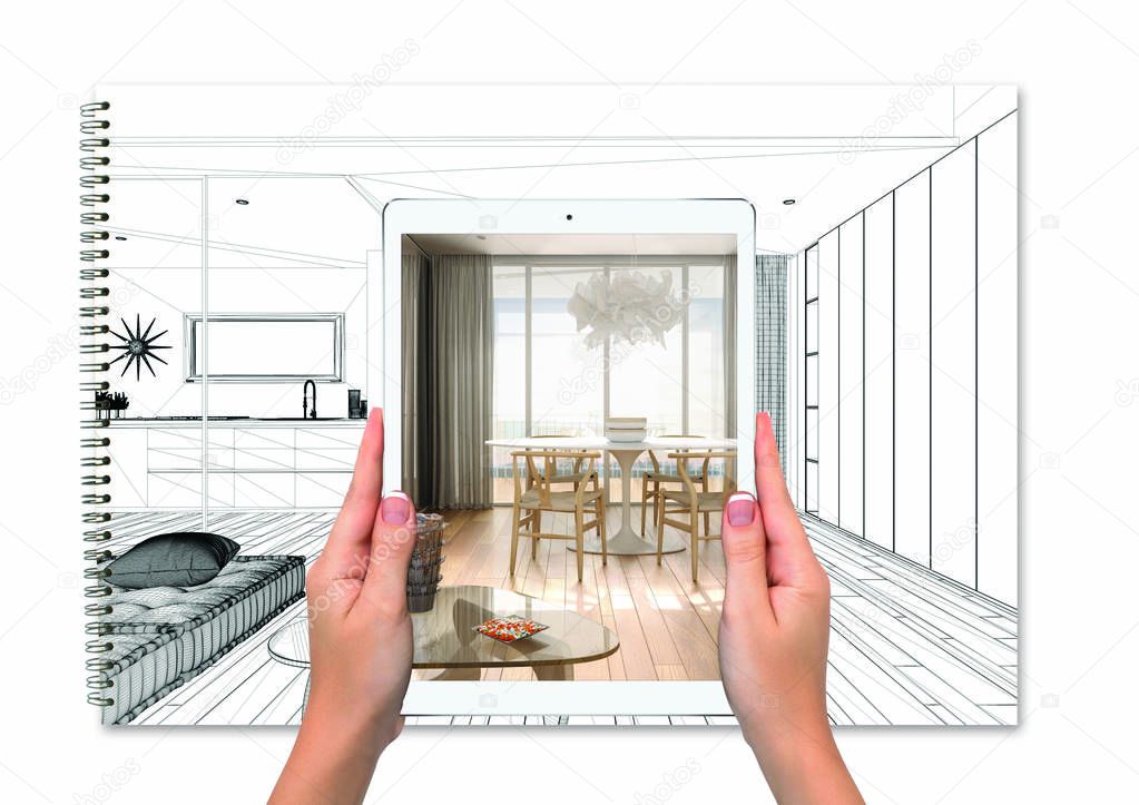 Hands holding tablet showing living room, notebook with blueprint sketch in the background, augmented reality concept, application to simulate furniture and interior design products
