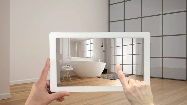 Conceito de realidade aumentada. Tablet de mão com aplicação AR usado para simular móveis e produtos de design em interior vazio com piso em parquet, banheiro moderno com banheira — Fotografia de Stock