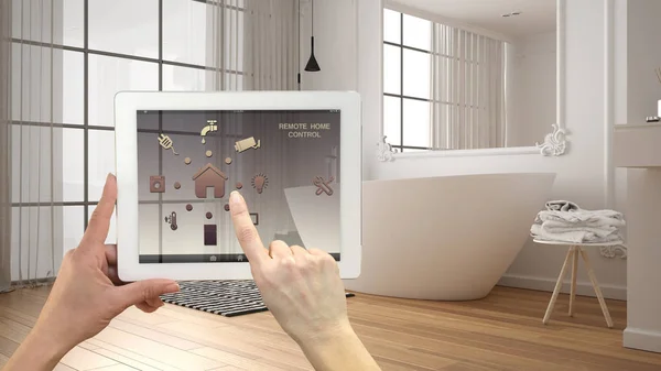 デジタルタブレット上のスマートリモートホームコントロールシステム。アプリのアイコンを持つデバイス。背景にバスタブ付きのミニマリストモダンな明るいバスルーム、建築インテリアデザイン — ストック写真