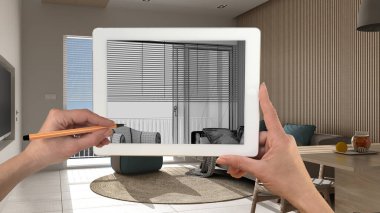 Klasik beyaz ve ahşap oturma odası detaylarını gösteren tablet üzerinde el ele tutuşmalar ve çizimler CAD çizimleri. Arka planda gerçekten bitmiş iç mimari tasarım sunumu