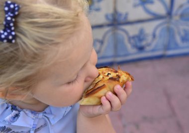 Kız Pasteis de Belem yumurta tart yiyor. Azulejos bir arka plan üzerinde döşeme