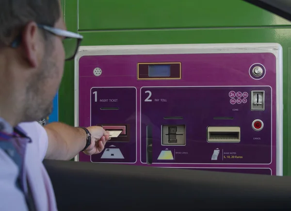 A man pays money for a toll road Toll gate motorway entrance