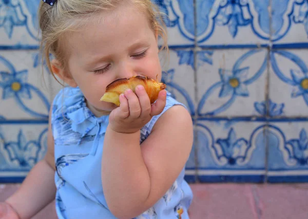 Kız Pasteis de Belem yumurta tart yiyor. Azulejos bir arka plan üzerinde döşeme