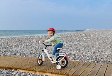 3 yaşında kız kask içinde bir dört tekerlekli bisiklet nea deniz sürme öğrenir