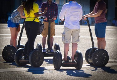 A group of people guided segway tour in a tourist place clipart