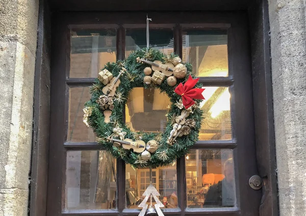 Christmas wreath with small miniatures on a glass door